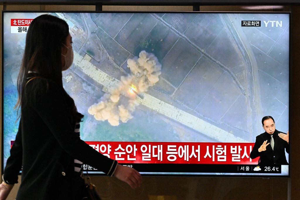 Mujer pasa ante televisor con noticias del envío de misiles en Seúl