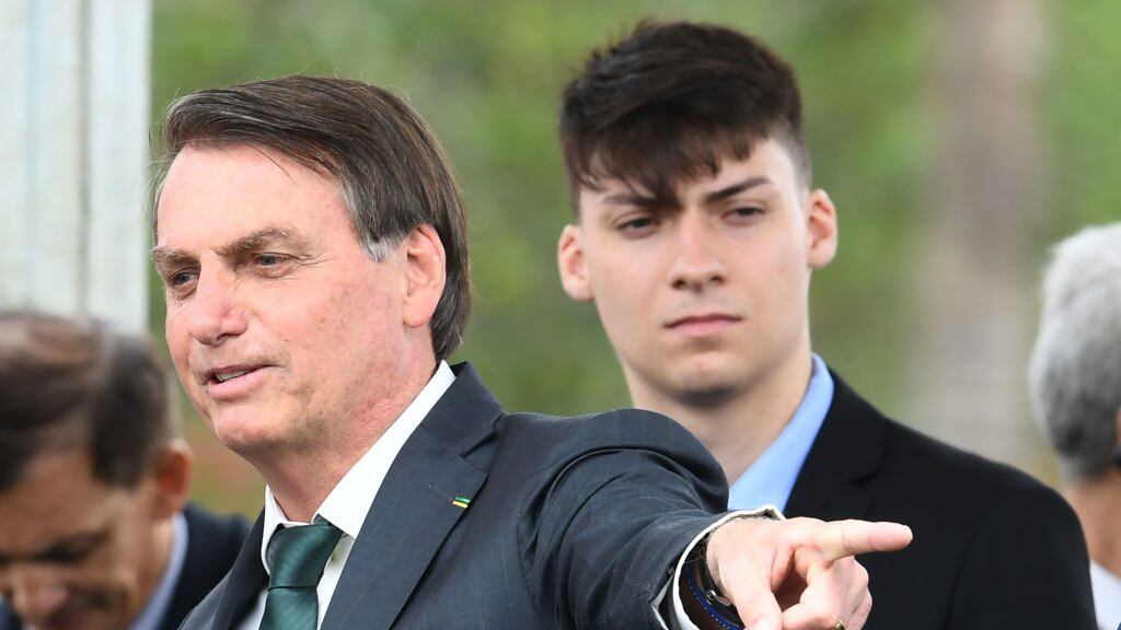 Brazilian President Jair Bolsonaro (R) gestures next to his son Jair Renan Bolsonaro, during the launch of his new party, the Alliance for Brazil, at a hotel in Brasilia on November 21, 2019. - Bolsonaro left the Social Liberal Party after a disagreement with the party president Luciano Bivar. (Photo by EVARISTO SA / AFP) (Photo by EVARISTO SA/AFP via Getty Images)