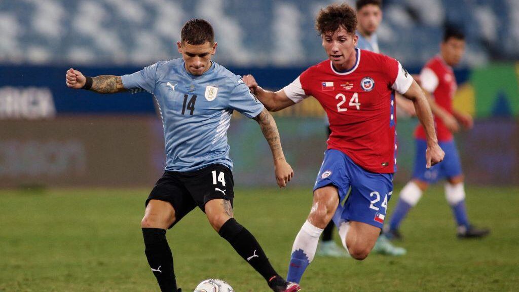 Uruguay's Lucas Torreira (L) and Chile's Luciano Arriagada vie for the ball during their Conmebol Copa America 2021 football tournament group phase match at the Pantanal Arena in Cuiaba, Brazil, on June 21, 2021. (Photo by SILVIO AVILA / AFP) (Photo by SILVIO AVILA/AFP via Getty Images)