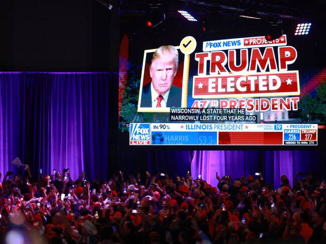 Seguidores republicanos muestran el aviso de Fox News proyectando el triunfo de Donald Trump en la elección presidencial 2024 de Estados Unidos