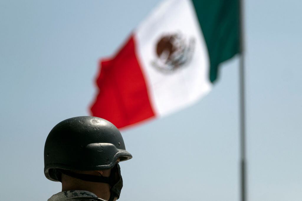 Un soldado cerca de la bandera de México