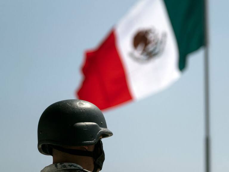 Un soldado cerca de la bandera de México