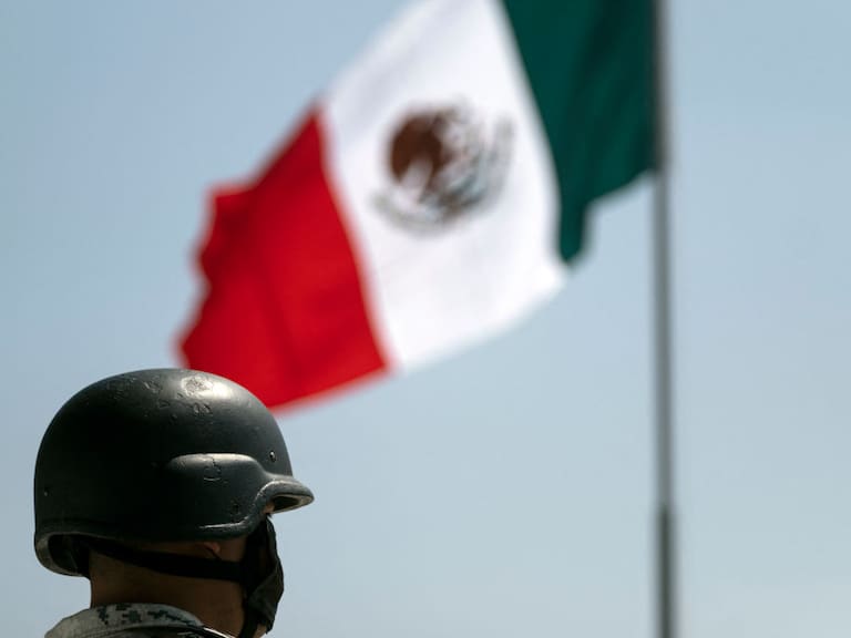Un soldado cerca de la bandera de México