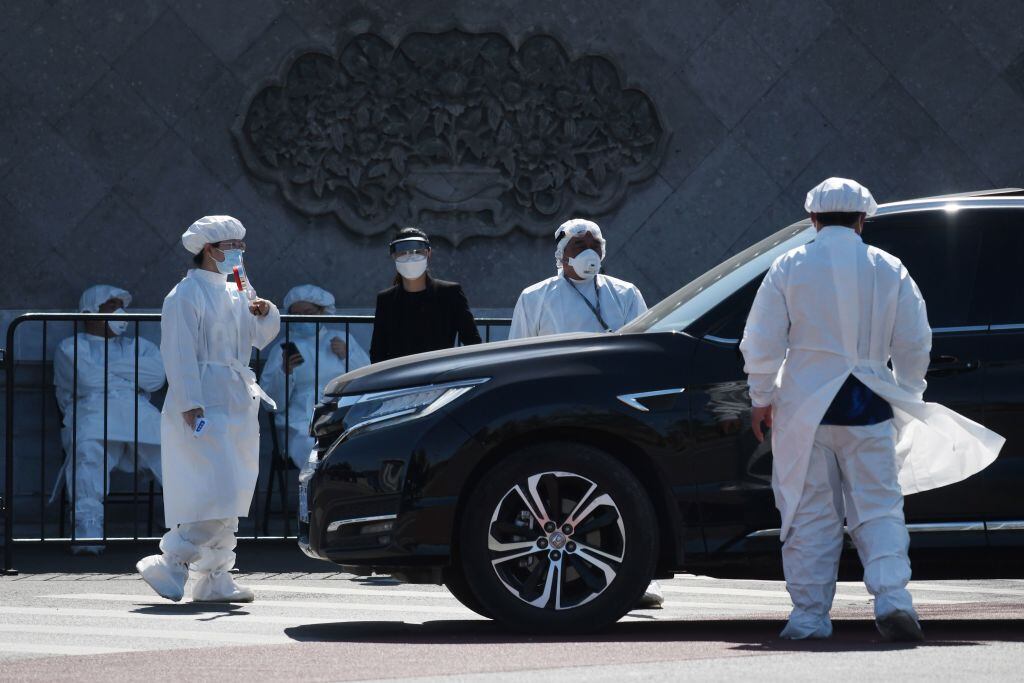 Personal sanitario controla a los vehículos y personas que llegan a un cementerio en China