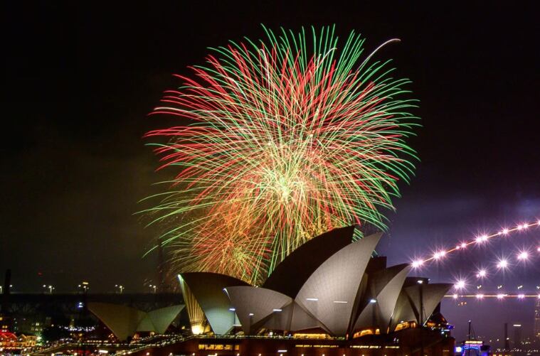 Los fuegos artificiales explotan sobre el puerto australiano de Sídney mientras comienzan las celebraciones de Año Nuevo.