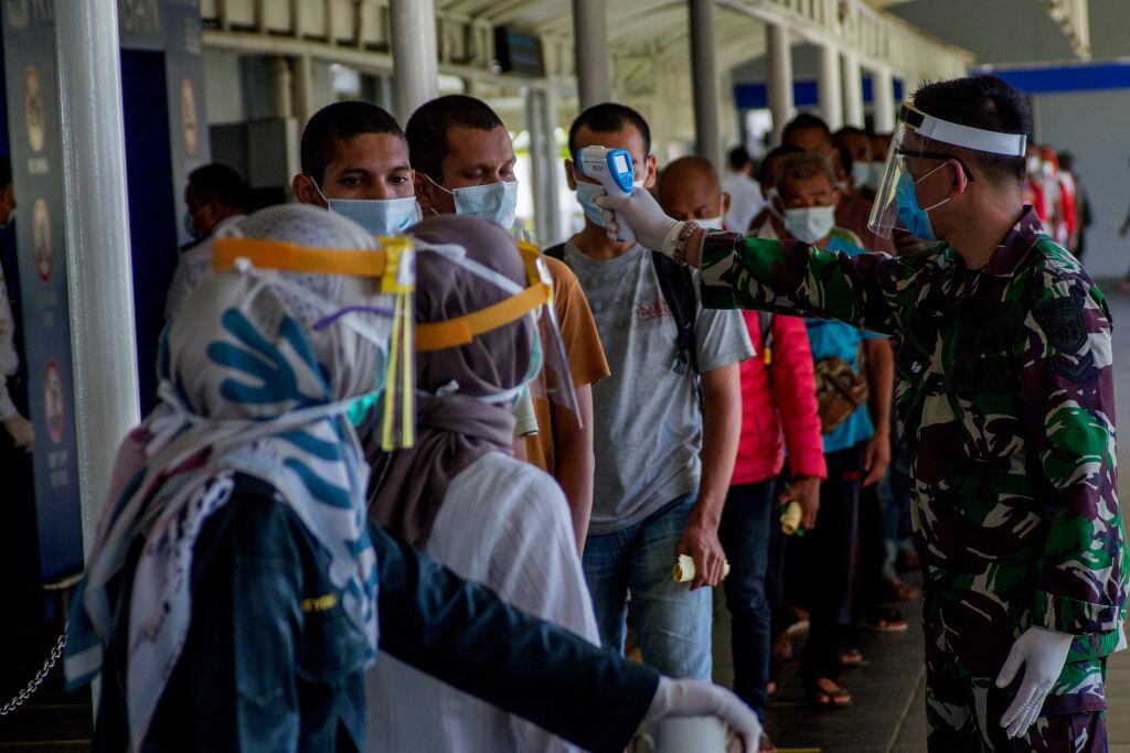 Unos médicos miden la temperatura de un grupo de trabajadores en Indonesia