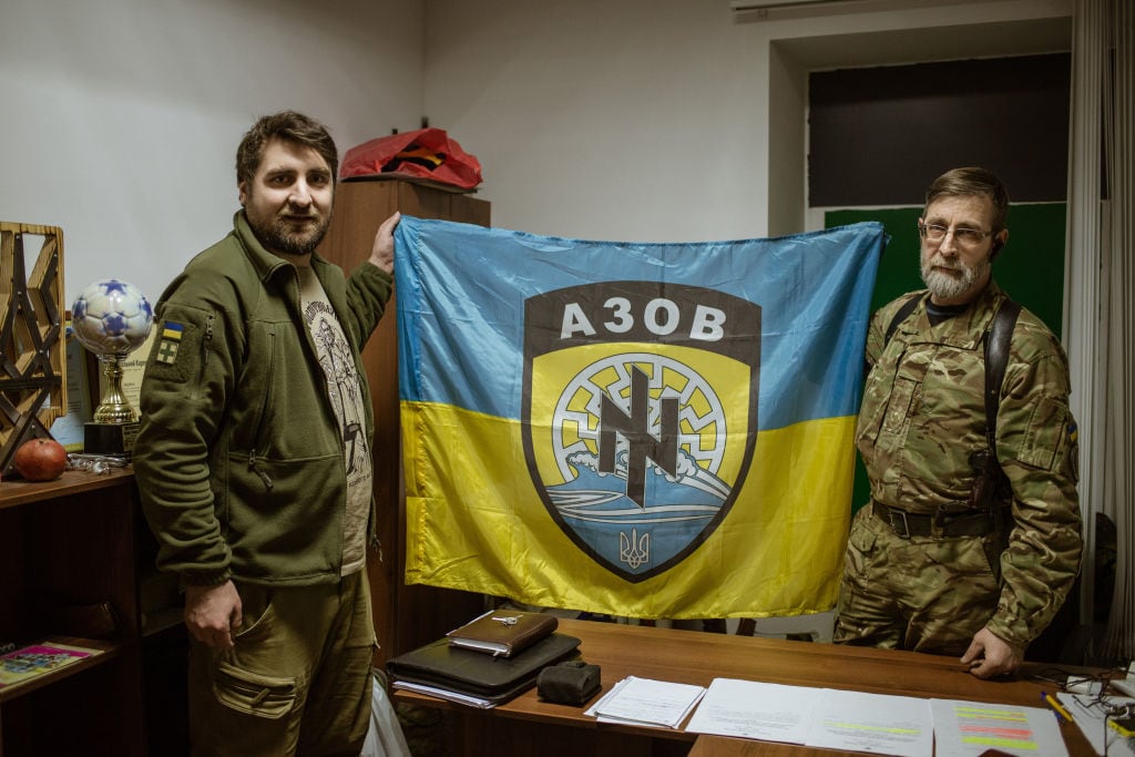 Miembros del Batallón de Azov con una bandera con un símbolo neonazi en Zaporizhzhia