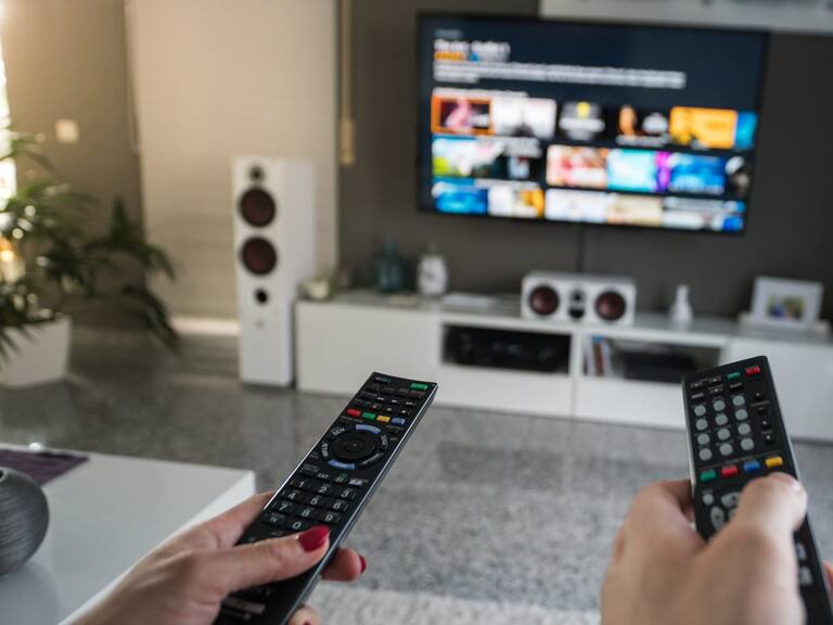 Inside a livingroom there is a battle going on about who is in charge of the television channels.