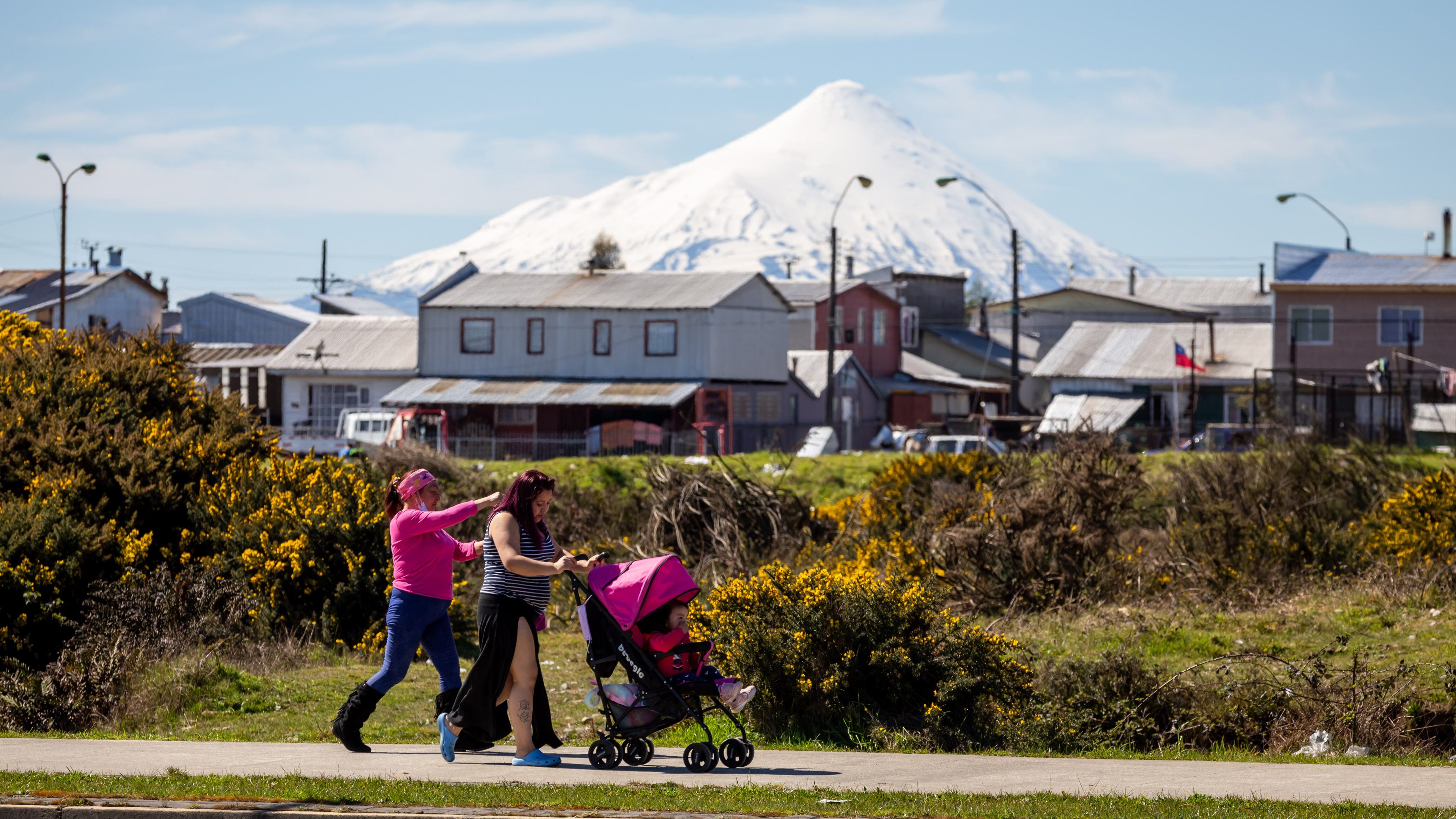 24 DE SEPTIEMBRE 2021 / PUERTO MONTTUna mujer con un coche camina por una calle del sector Alerce en donde se puede ver de fondo el Volcán Osorno, durante un día soleado de primavera
FOTO: FELIPE CONSTANZO / AGENCIAUNO