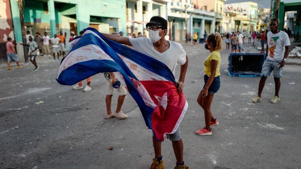 A man waves a Cuban flag during a demonstration against the government of Cuban President Miguel Diaz-Canel in Havana, on July 11, 2021. - Thousands of Cubans took part in rare protests Sunday against the communist government, marching through a town chanting "Down with the dictatorship" and "We want liberty." (Photo by ADALBERTO ROQUE / AFP) (Photo by ADALBERTO ROQUE/AFP via Getty Images)