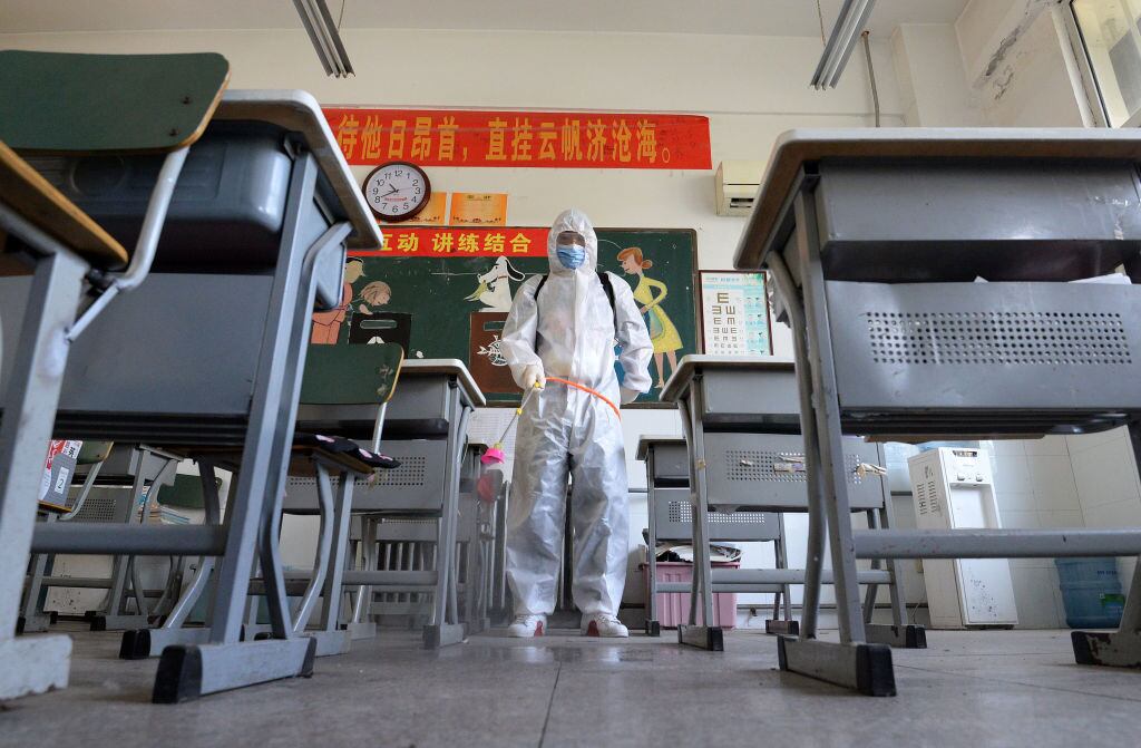 Trabajadores sanitarios desinfectan una sala de clases en la ciudad china de Handan