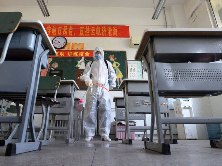 Trabajadores sanitarios desinfectan una sala de clases en la ciudad china de Handan
