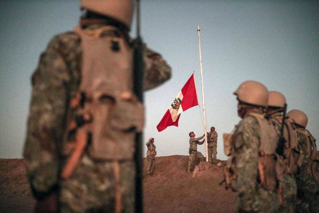 Militares peruanos izan la bandera de su país en las cercanías de la frontera del Perú.