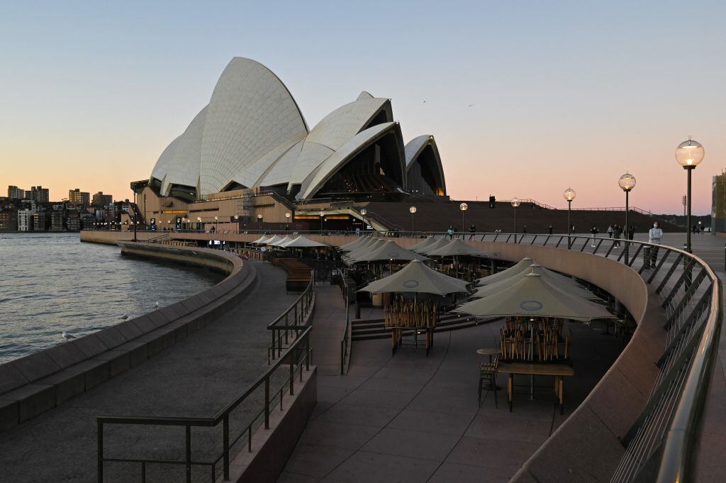 Tables and chairs sit empty along the water in Circular Quay, usually full of visitors at the weekend, in central Sydney on June 27, 2021, on the first full day of a two-week coronavirus lockdown to contain an outbreak of the highly contagious Delta variant. (Photo by Steven Saphore / AFP) (Photo by STEVEN SAPHORE/AFP via Getty Images)
