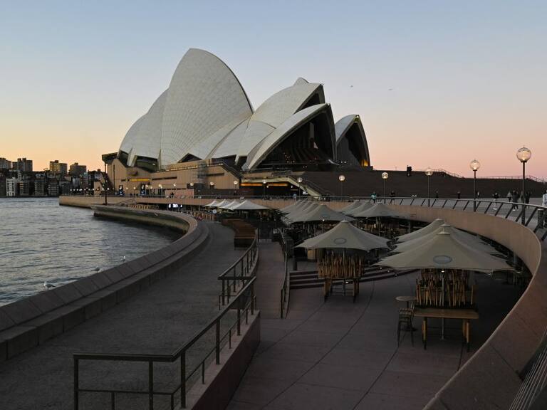 Tables and chairs sit empty along the water in Circular Quay, usually full of visitors at the weekend, in central Sydney on June 27, 2021, on the first full day of a two-week coronavirus lockdown to contain an outbreak of the highly contagious Delta variant. (Photo by Steven Saphore / AFP) (Photo by STEVEN SAPHORE/AFP via Getty Images)