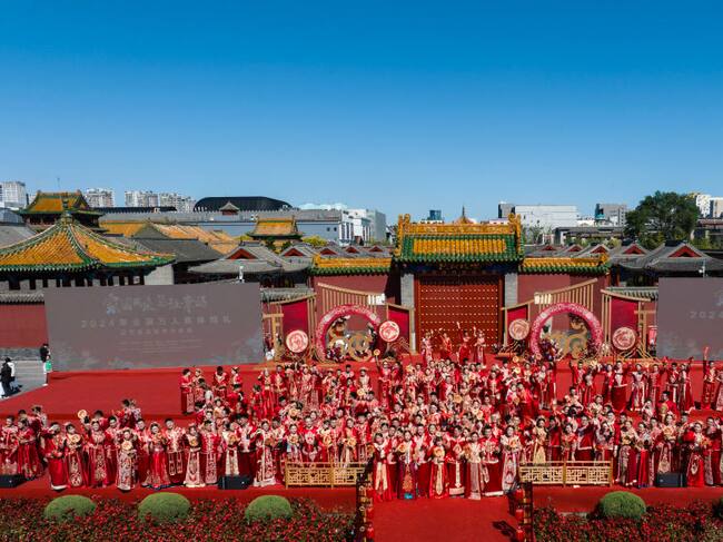 SHENYANG, CHINA - SEPTEMBER 22: Newly-wed couples attend a group wedding in traditional Chinese style under the witness of their families and friends in the South Square at Shenyang Imperial Palace on September 22, 2024 in Shenyang, Liaoning Province of China. (Photo by Cai Jingyu/VCG via Getty Images)