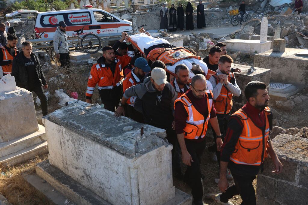 Voluntarios y paramédicos transportan el cuerpo de un palestino muerto tras el ataque de Israel contra un edificio residencial en la Franja de Gaza