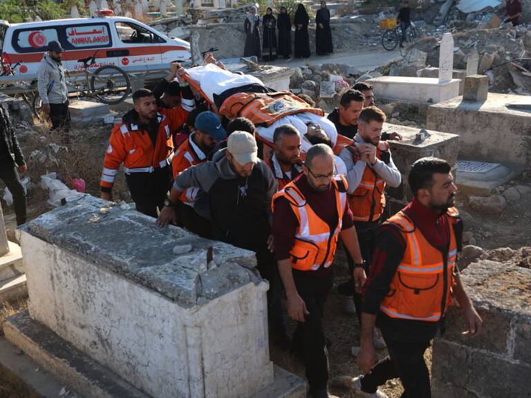 Voluntarios y paramédicos transportan el cuerpo de un palestino muerto tras el ataque de Israel contra un edificio residencial en la Franja de Gaza
