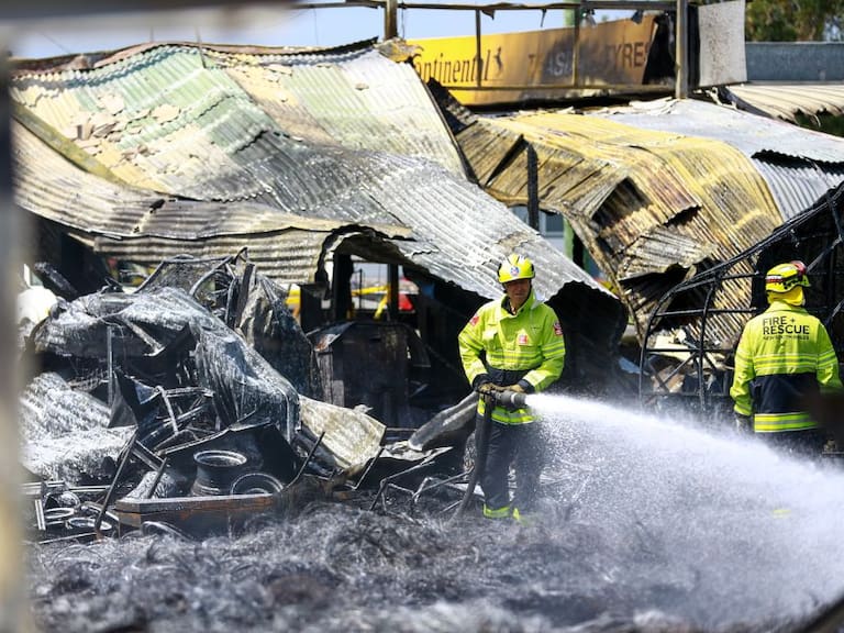 Equipos de bomberos combaten un incendio forestal que consumió unas estructuras en Australia.