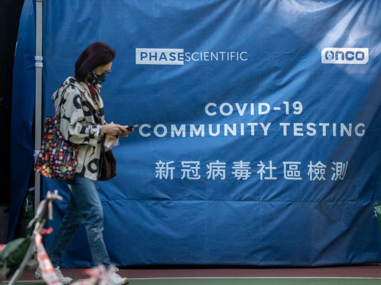 A women walks pass a tent at Covid-19 testing center on January 19, 2023 in Hong Kong, China. The Chinese New Years of Lunar New Years Holiday starts next week, this year is the Year of the Rabbit in the Chinese Zodiac Calendar, China requires People entering the country to produce a negative PCR Covid-19 test. (Photo by Vernon Yuen/NurPhoto via Getty Images)