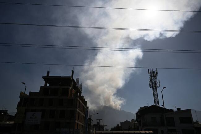 El humo que provoca un incendio forestal sobre un cerro se coloca sobre algunas zonas de la ciudad de Bogotá en Colombia, ante la alerta del gobierno.