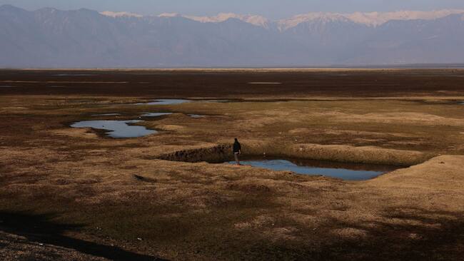 Un niño camina por un río completamente seco en la región de Cachemira en la India, por la sequía que provoca el calentamiento global.