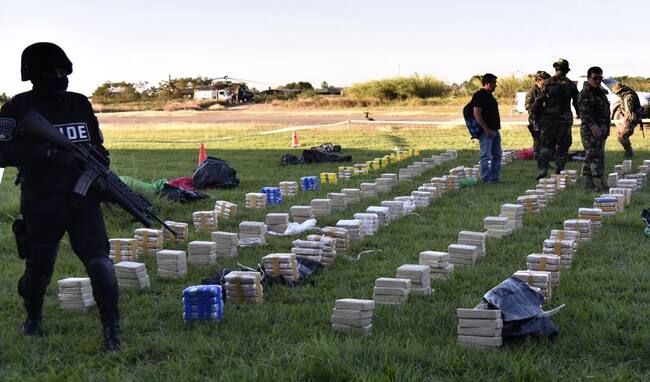 Miembros de las fuerzas especiales de la policía custodian la carga de cocaína incautada en Bolivia.