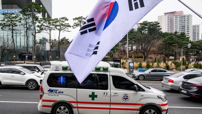 Una ambulancia pasa ante una bandera de Corea del Sur, en medio de una huelga general de los médicos en ese país asiático.