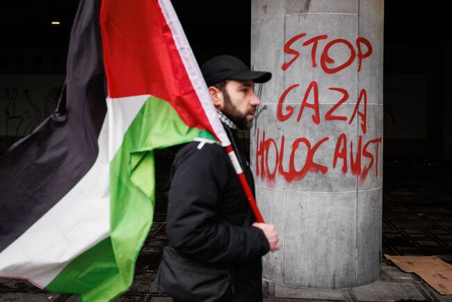 Manifestante lleva una bandera de Palestina tras participar de un acto en la ciudad de Bruselas en Bélgica en contra del genocidio en los territorio palestinos