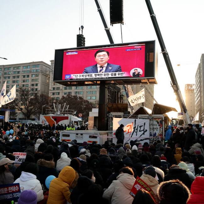 La imagen del presidente de Corea del Sur, Yoon Suk Yeol, en una pantalla gigante en las calles de Seúl mientras el parlamento votaba su destitución