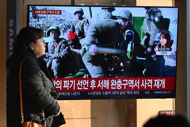 Mujer camina ante una televisión en Seúl, donde se informa del lanzamiento de proyectiles realizado por Corea del Norte ante las costas surcoreanas.