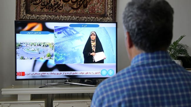 Hombre mira la televisión en la ciudad de Teherán, mientras el canal reporta una &quot;explosión masiva&quot; en Isfahán.