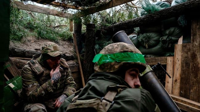 Dos soldados del Ejército de Ucrania se protegen al interior de una trinchera en la región de Donetsk.