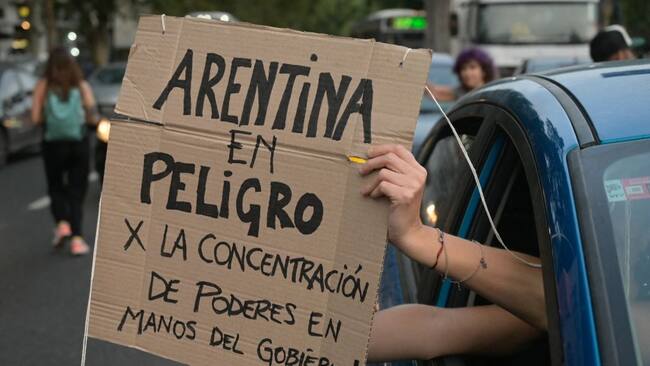 Una persona levanta un cartel contra el Plan Milei al pasar por las afueras del Congreso de Argentina en la ciudad de Buenos Aires.