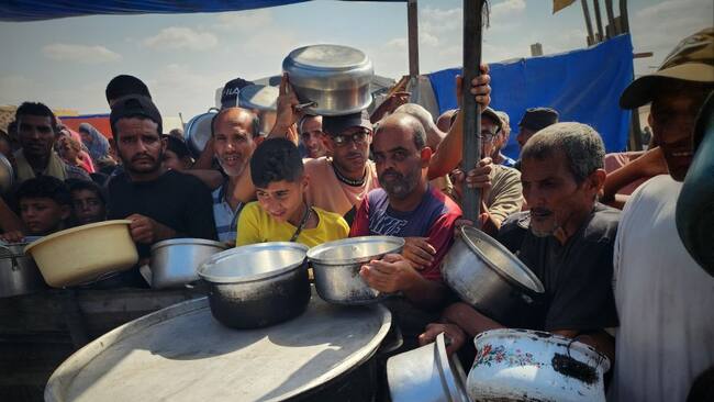 En la Franja de Gaza se agolpan para recibir alimentos en sus platos, mientras esperan comida y sobrevivir los ataques militares de Israel