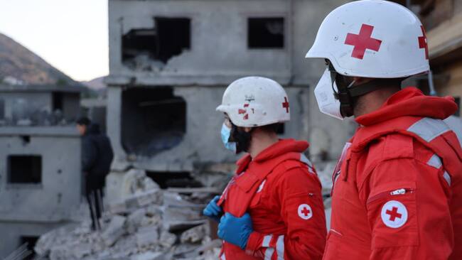 Miembros de la Cruz Roja observan la destrucción que dejan los bombardeos de Israel en contra del Líbano