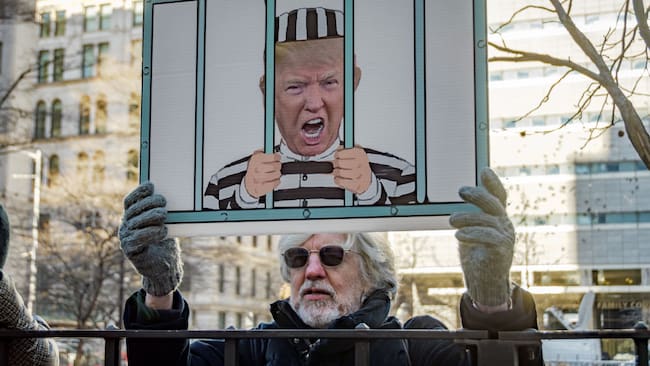Personas llegaron con carteles para manifestarse contra Donald Trump, a las afueras de los tribunales de la ciudad de Nueva York en Estados Unidos.