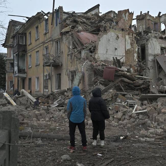 Personas observan la destrucción de un edificio que dejan los ataques aéreos de Rusia en la localidad de Selídove, en la región de Donetsk en Ucrania.