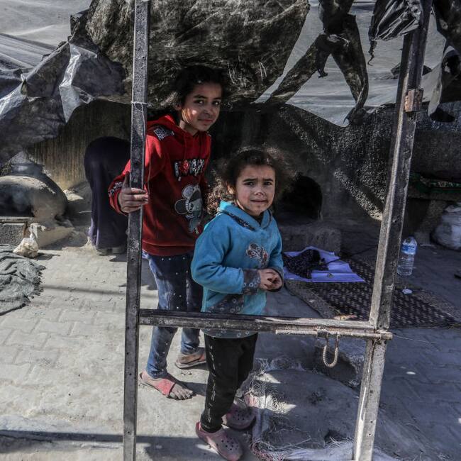 Dos niños palestinos en medio de un campamento de refugiados en la zona de Rafah de la Franja de Gaza, cerca de los ataques de Israel a ese enclave.
