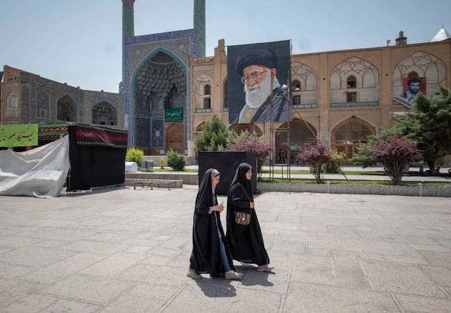 Dos mujeres caminan frente a una mezquita en la ciudad iraní de Isfahán.