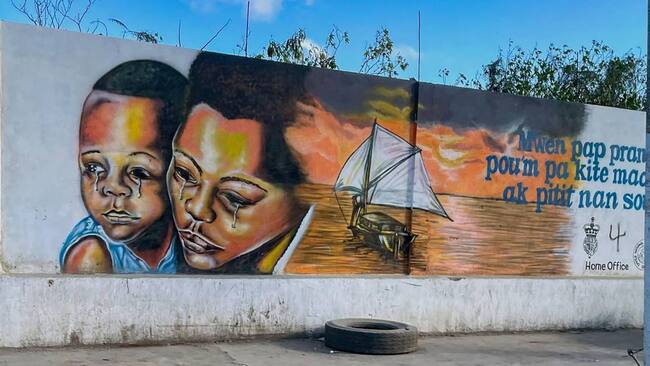 Mural sobre los riesgos de la migración irregular en una de las calles de la ciudad portuaria de Cabo Haitiano en Haití.