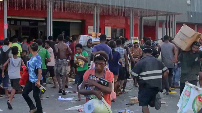 Las personas saquean una tienda en Puerto Moresby, en medio de la protesta de policías, soldados y gendarmes en Papúa Nueva Guinea.