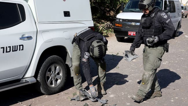 Policías de Israel revisan los restos de un cohete lanzado por Hezbolá que impactó en los alrededores de la ciudad de Tel Aviv