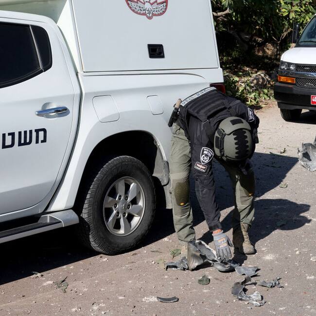 Policías de Israel revisan los restos de un cohete lanzado por Hezbolá que impactó en los alrededores de la ciudad de Tel Aviv
