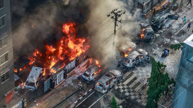 El humo se levanta tras incendiarse la sede de un canal de televisión en medio de las protestas estudiantiles contra el gobierno en Bangladesh.