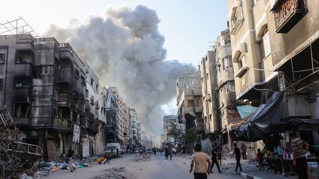 Palestinos observan el humo que se levanta producto de un nuevo bombardeo de Israel sobre la Franja de Gaza en Palestina.