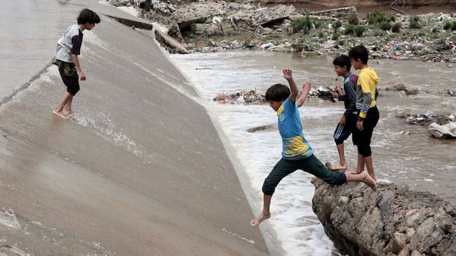 Un grupo de niños juega sobre las calles inundadas tras las lluvias torrenciales en Yemen.