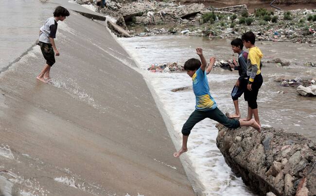 Un grupo de niños juega sobre las calles inundadas tras las lluvias torrenciales en Yemen.