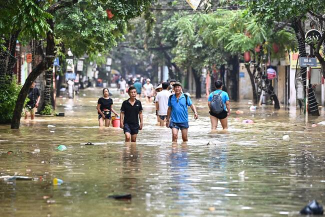 Las personas avanzan por las calles de la ciudad de Hanói en Vietnam tras el paso del supertifón Yagi