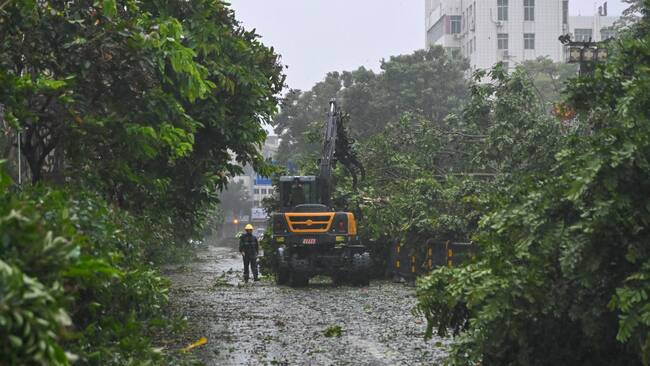 Los trabajadores en la ciudad de Zhanjiang, de la provincia de Hainan, intentan despejar los caminos tras el arribo del supertifón Yagi a China